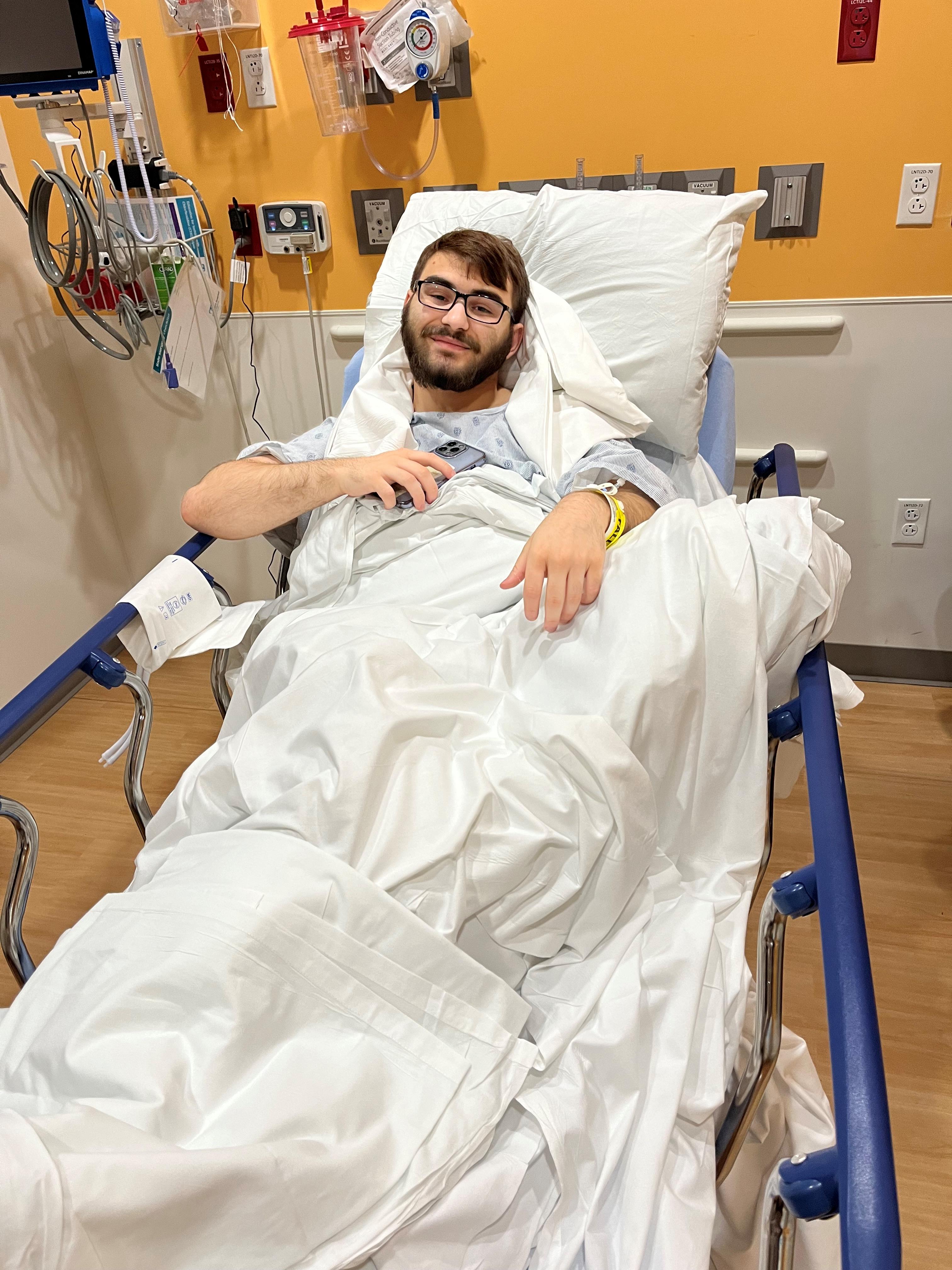 Tristen laying in a hospital bed prior to ACL surgery