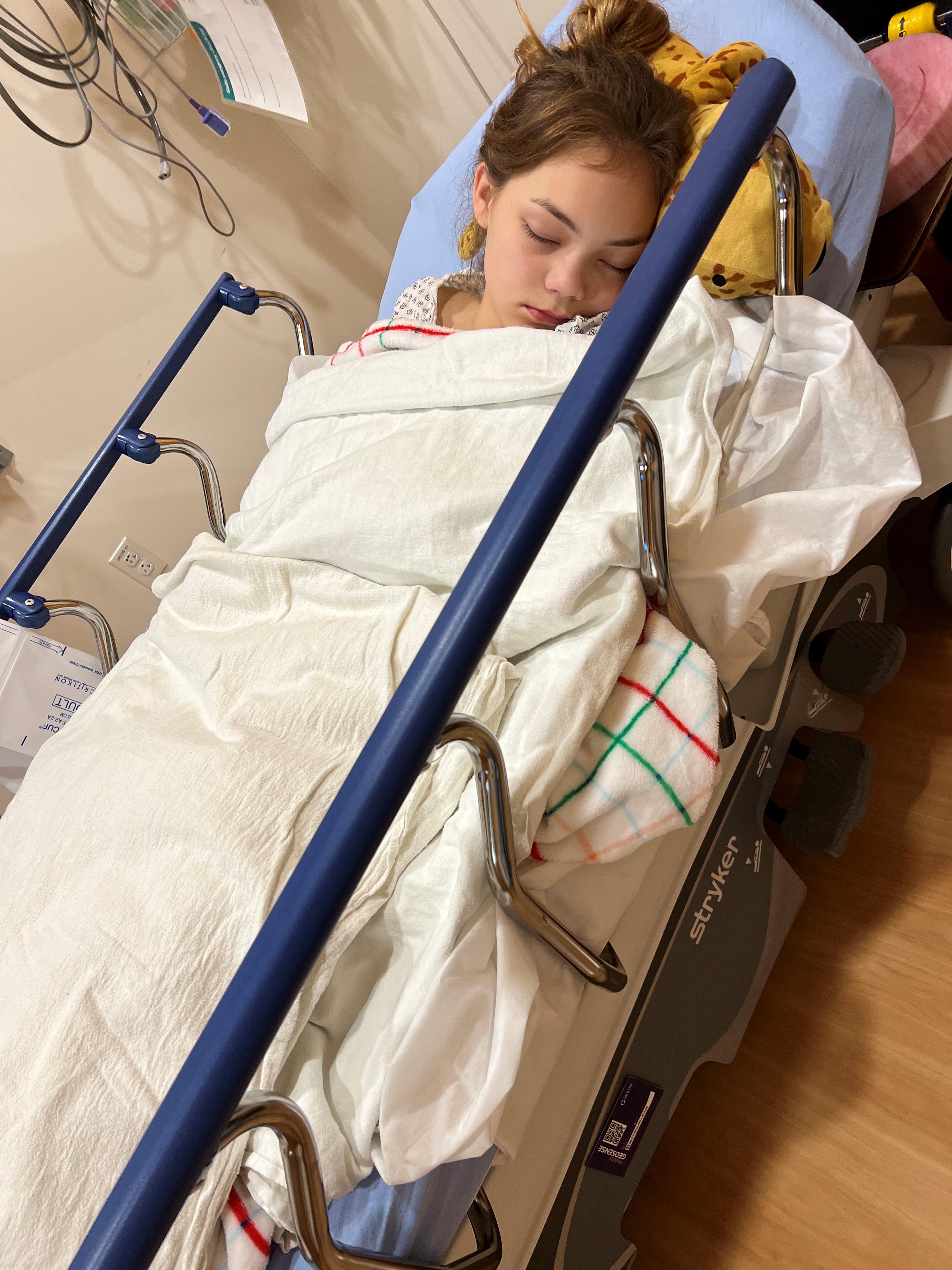 Erin Gee, teen tennis player with hip dysplasia, sleeps in a hospital bed.